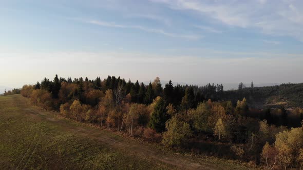 Flight over autumn mountains in the light of the setting sun