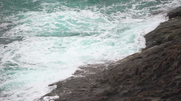 Sea Foam Falls on The Rocky Shore. Turquoise Waves in The Ocean