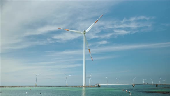 Blue sky and sea and wind turbine. Green energy and environment.