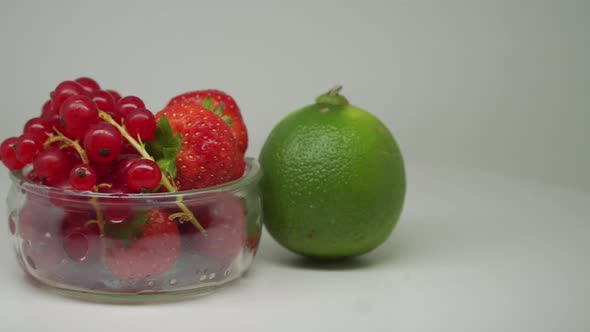 Strawberries and Cherries inside the white transparent bowl with lime on the outside Rotating In the