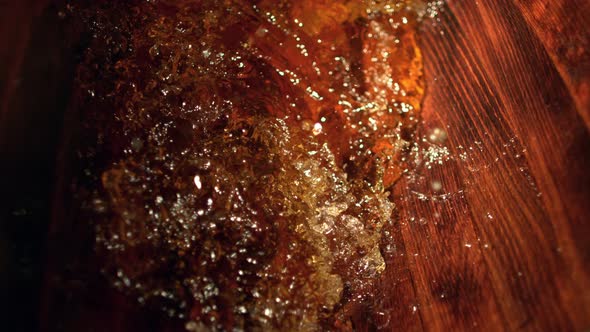 Super Slow Motion Detail Shot of Splashing Whiskey in Wooden Barrel at 1000Fps