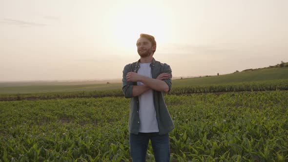 Young Smiled Man Looks on His Crops