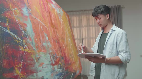 Asian Man Working On Abstract Painting