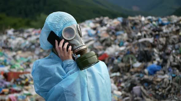 Woman wearing a gas mask on a landfill, a lot of garbage, an ecological catastrophe