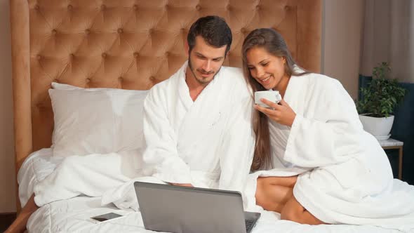 Young Couple Having Coffee in Bed While Using Laptop 1080p