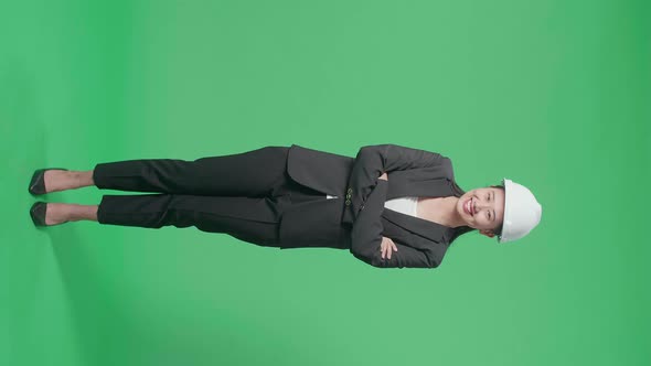 Asian Female Engineer Putting On The Safety Helmet And Crossing Her Arms In The Green Screen Studio