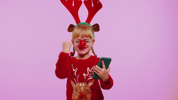 Girl Child in Christmas Deer Antlers Looking Smartphone Display Sincerely Rejoicing Win Success Luck