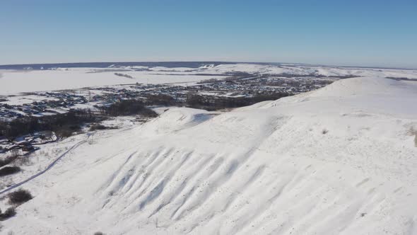 The Village Appears From Behind the Snowy Mountains on a Bright Sunny Day