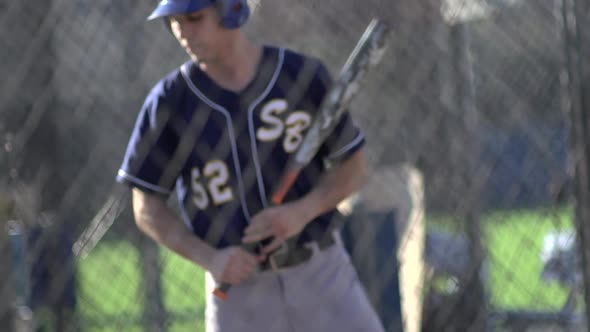 A young man practices baseball at the batting cages.