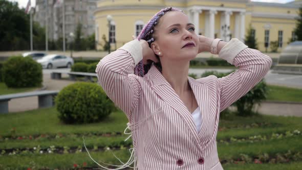 A Young Creative Businesswoman in a Pink Suit Looks Into the Camera