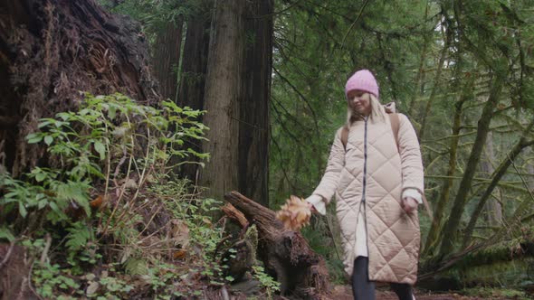 Beautiful Smiling Woman Enjoying Walk By Scenic Green Forest with Giant Redwoods