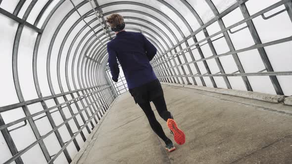 Running Man In Sportswear Workout Before Triathlon Sprinting In Glass Tunnel