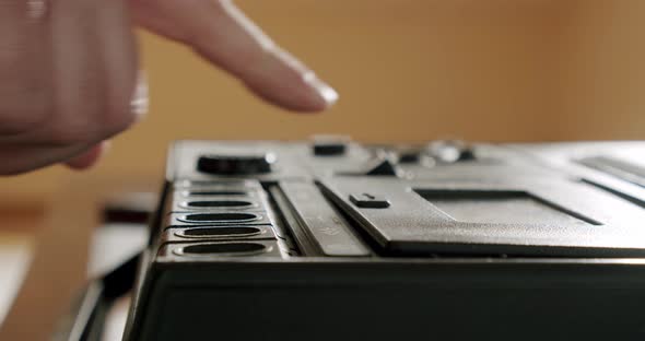 Male Hands Extract an Audio Cassette Into a Retro Tape Recorder