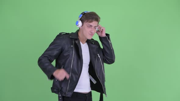 Happy Young Rebellious Man Listening To Music and Dancing