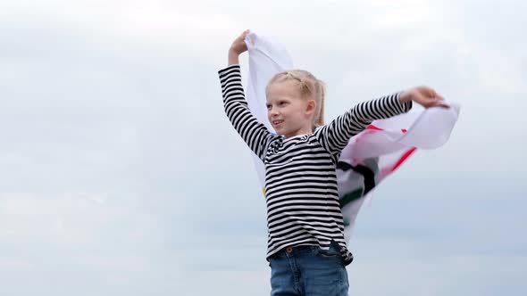 Blonde Girl Waving Flag the Olympic Games Outdoors Over Cloudy Sunset Sky