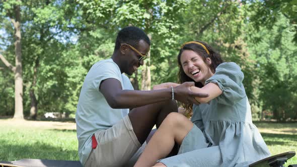 Cheerful Man and Woman Eat Ice Cream Sitting in City Park