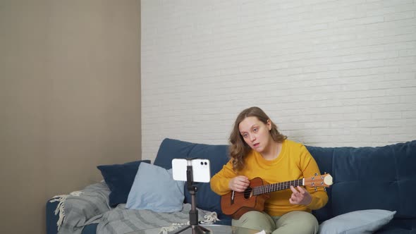 Woman Learns to Play the Ukulele By Watching Video Tutorial on Phone