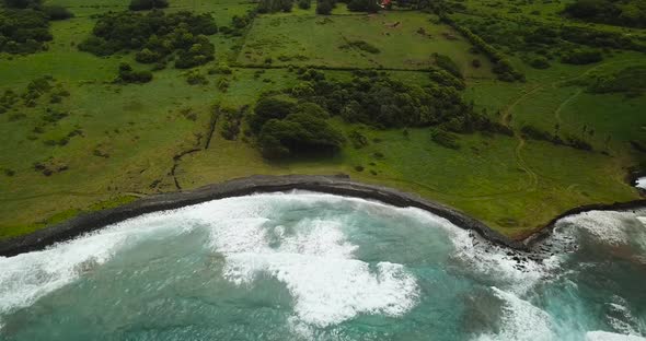 An aerial shot of a beach. The shots spins, pans and goes lower.