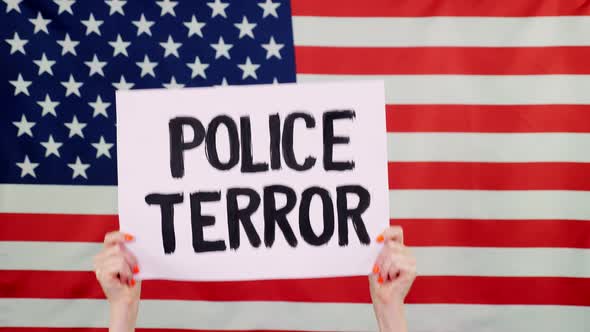 Protester Holds a Banner with a Slogan - Police Terror - Against Background of the USA Flag