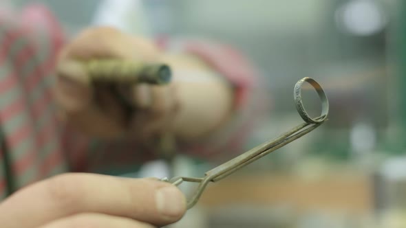 Close ups of a craftsman making jewellery in a workshop.