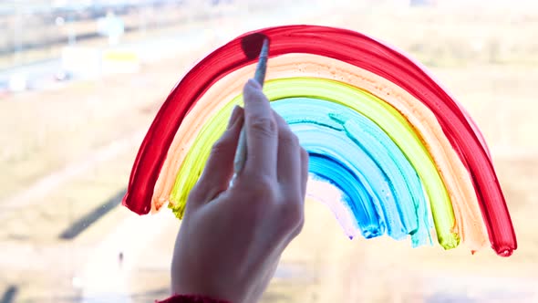 Girl Painting Rainbow on Window During Covid19 Quarantine at Home