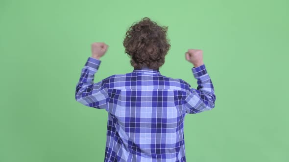 Rear View of Happy Young Hipster Man with Fists Raised