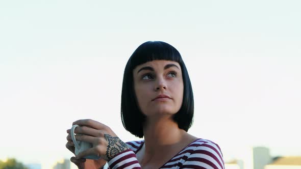 Woman having coffee in the balcony 