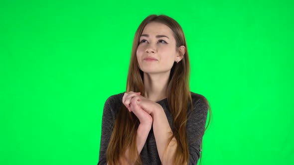 Portrait of Cute Brunette with Long Hair Is Daydreaming on a Green Screen