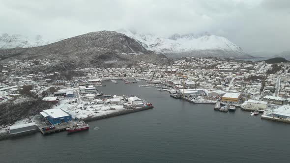 Skjervoy Village Houses Covered With Fresh Snow With Fishing Port In Norway. - aerial approach