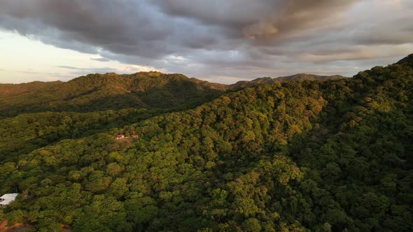 Slow cinematic drone video of epic cloudscape over lush central American mountainous rainforest. War