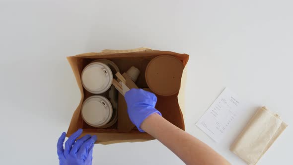 Hands in Gloves Packing Takeaway Food for Customer