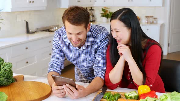 Couple using digital tablet in kitchen at home 