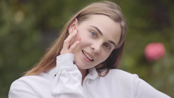 Portrait of Confident Carefree Beautiful Young Smiling Woman with Different Colored Eyes Looking