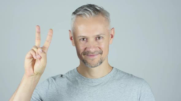 Portrait OF  Middle Age Man Showing Victory Sign