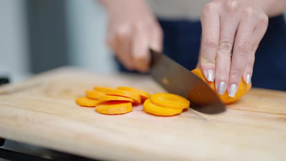4K Close up of Asian woman hand using knife cutting carrot on cutting board in the kitchen