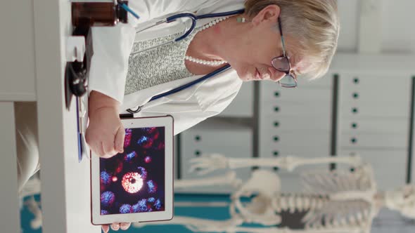 Vertical Video Female Physician Holding Digital Tablet with Coronavirus Animation