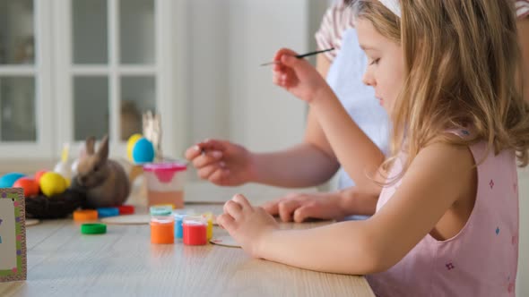 Little Girl with Mother Making Easter Decorations