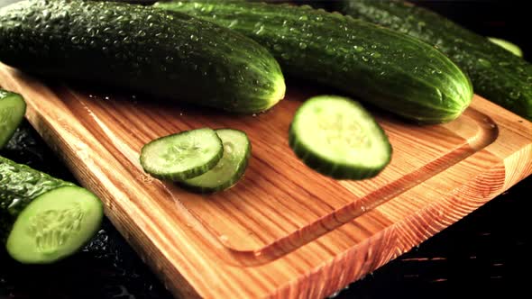 Pieces of Fresh Cucumber Fall on the Cutting Board