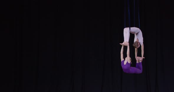 Performance on Stage Two Girls Doing Aerial Gymnastics Spinning in the Air