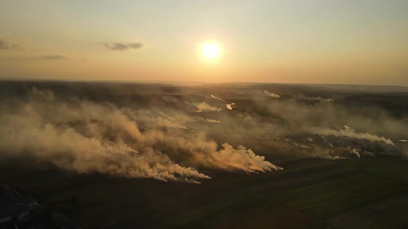 Aerial Shot In Ukraine At Sunset, Burning Grass. Emissions Into The Atmosphere
