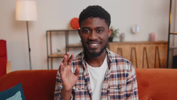 Man Sitting on Home Sofa Looking at Camera Making Video Conference Call with Friends or Parents