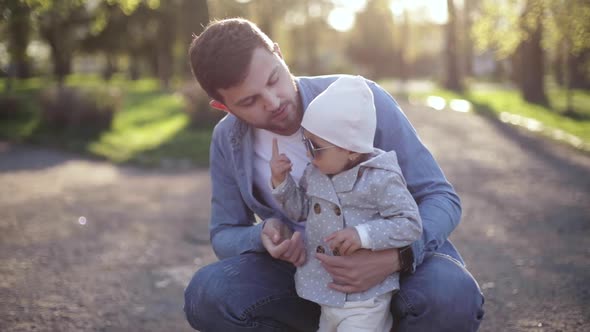 Dad Put on Sunglasses To His Little Daughter in Suuny Day