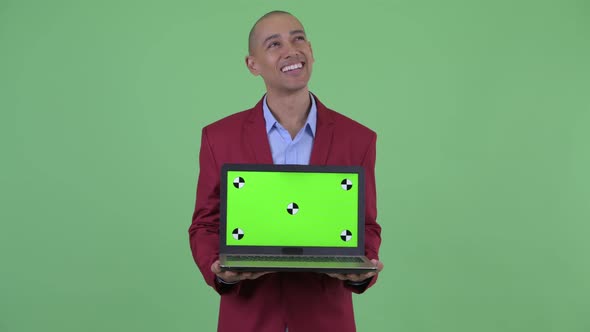 Happy Bald Multi Ethnic Businessman Thinking While Showing Laptop and Talking