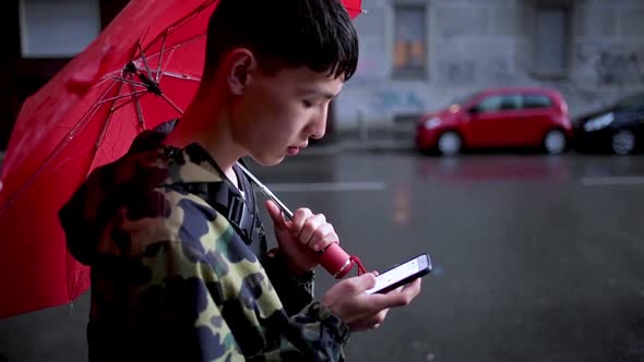 Young man using smartphone leaning on wall in city