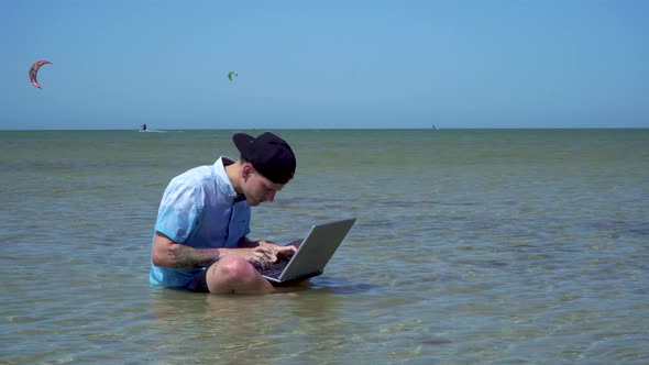 A Man Works on Vacation. The Guy in the Sea with a Laptop.