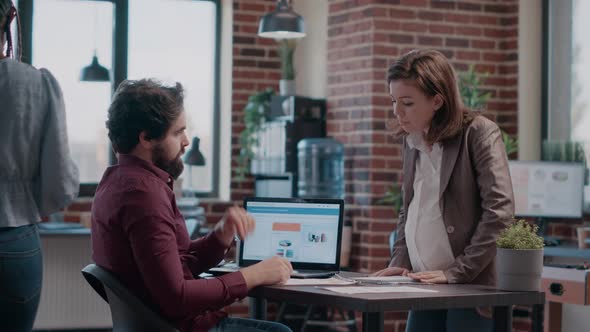 Business Man Talking to Pregnant Colleague About Project Planning