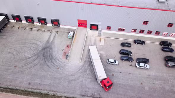 Big distribution warehouse with gates for loads and trucks Reversing Into A Loading Dock. Aerial Sho