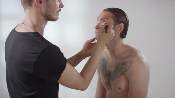 Male MUA Applying Eyeliner on Male Model