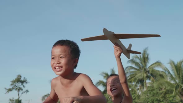 Happy Rural Children Riding Bike And Playing A Cardboard Airplane