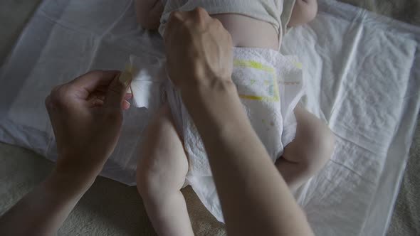 Close Up Mother is Putting on Newborn Baby's Diaper